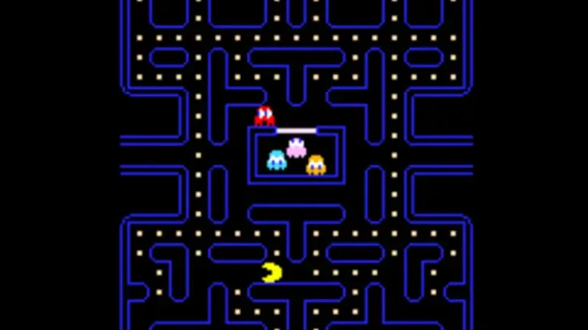 Pac-Man moves through the classic blue maze while Blinky and the other ghosts gather near the center.