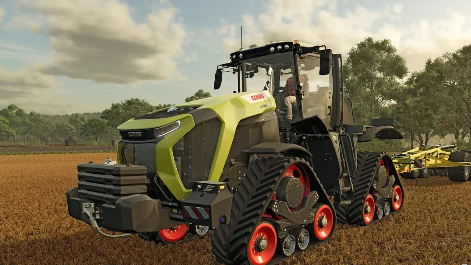A large Claas tracked tractor drives across a harvested field in Farming Simulator 25.