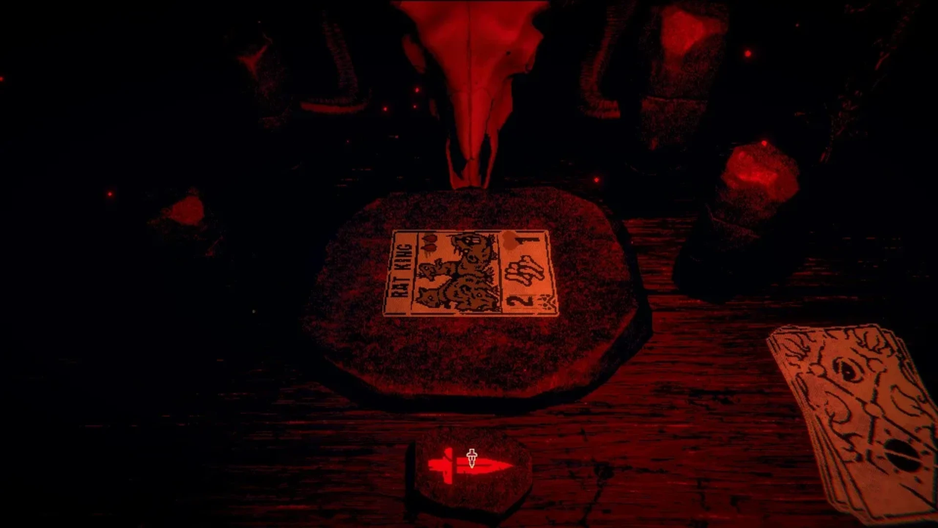 A Rat King card rests on the table inside the dark red-lit cabin in Inscryption.