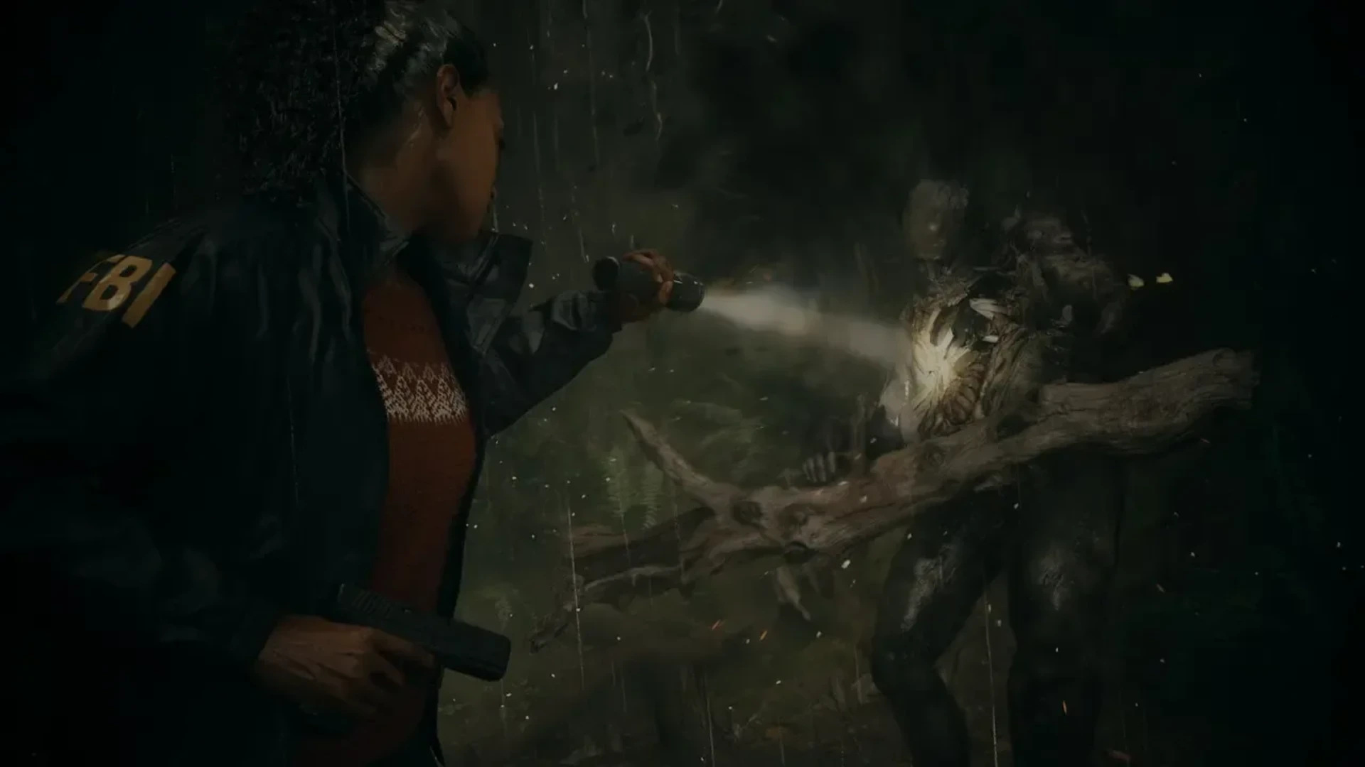 Saga Anderson shines a flashlight at a Taken enemy while holding a handgun in Alan Wake 2.