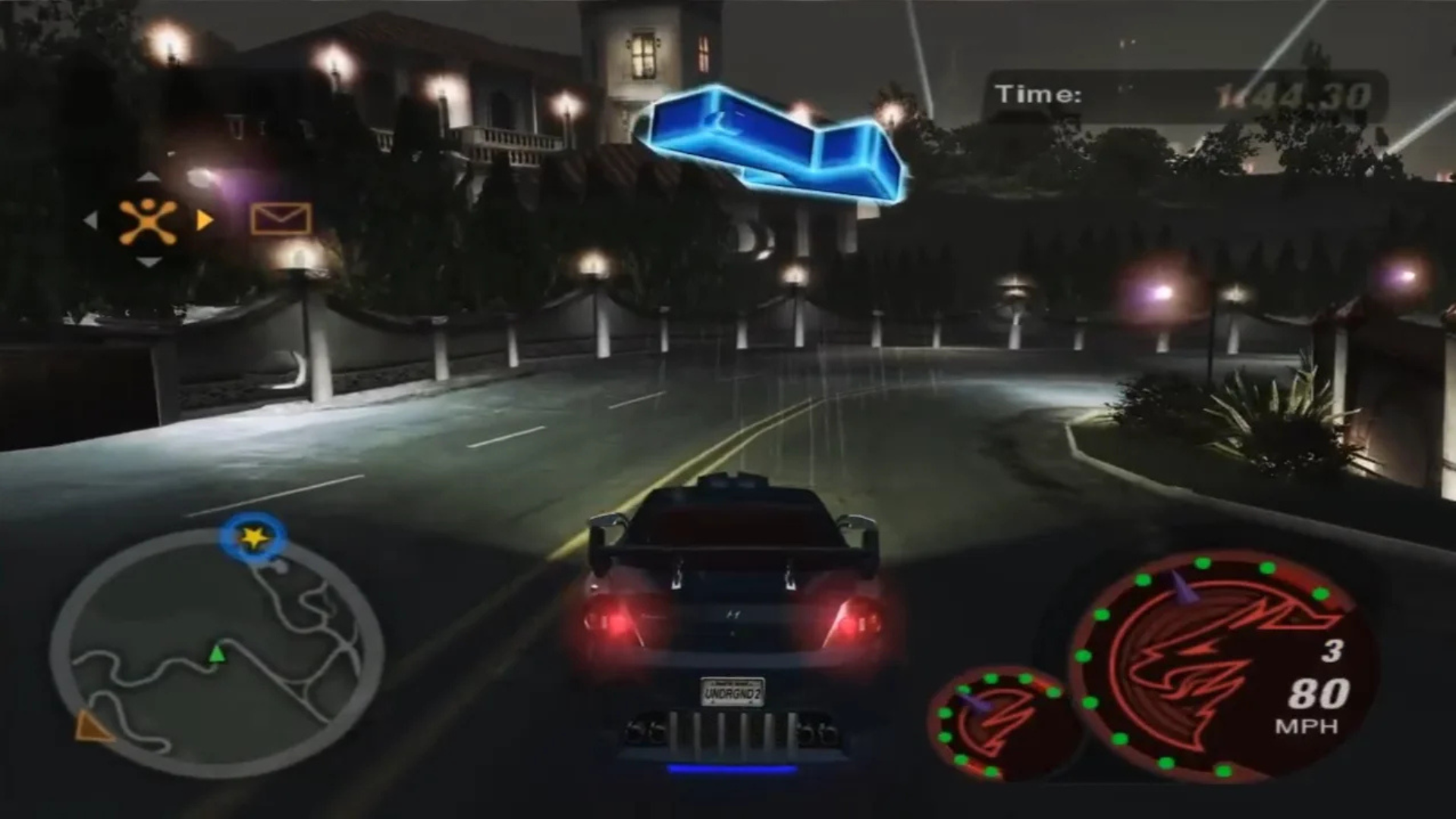 Night race gameplay in Need for Speed Underground 2, with a customized car driving through the streets of Bayview.