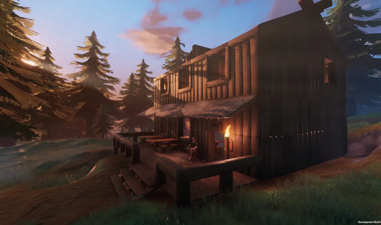 A Viking sits outside a large wooden inn surrounded by pine trees at sunset in Valheim.