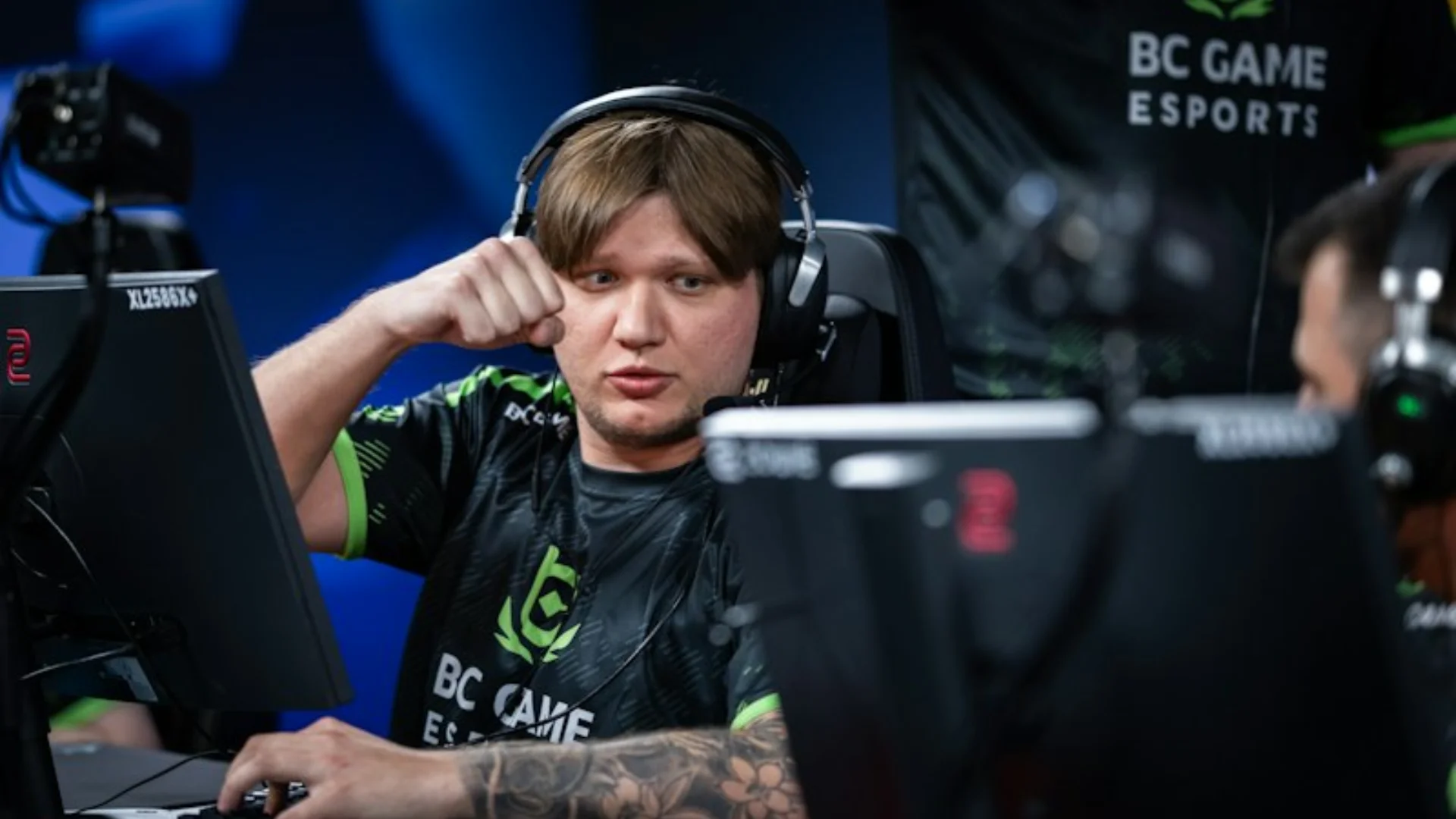 BC.Game Counter-Strike 2 player wearing a headset and raising his fist during an esports competition.