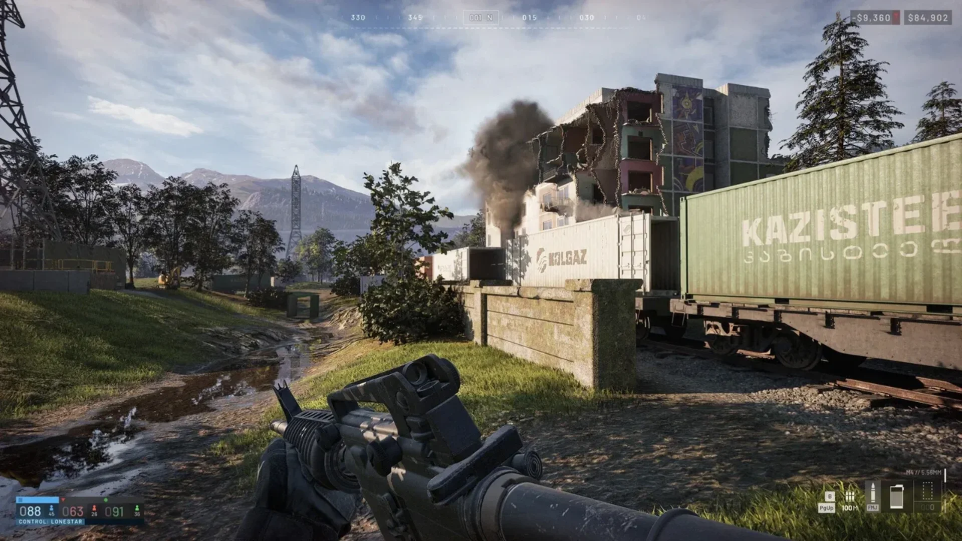 A WARDOGS player aims a rifle beside freight cars as smoke rises from a damaged building.