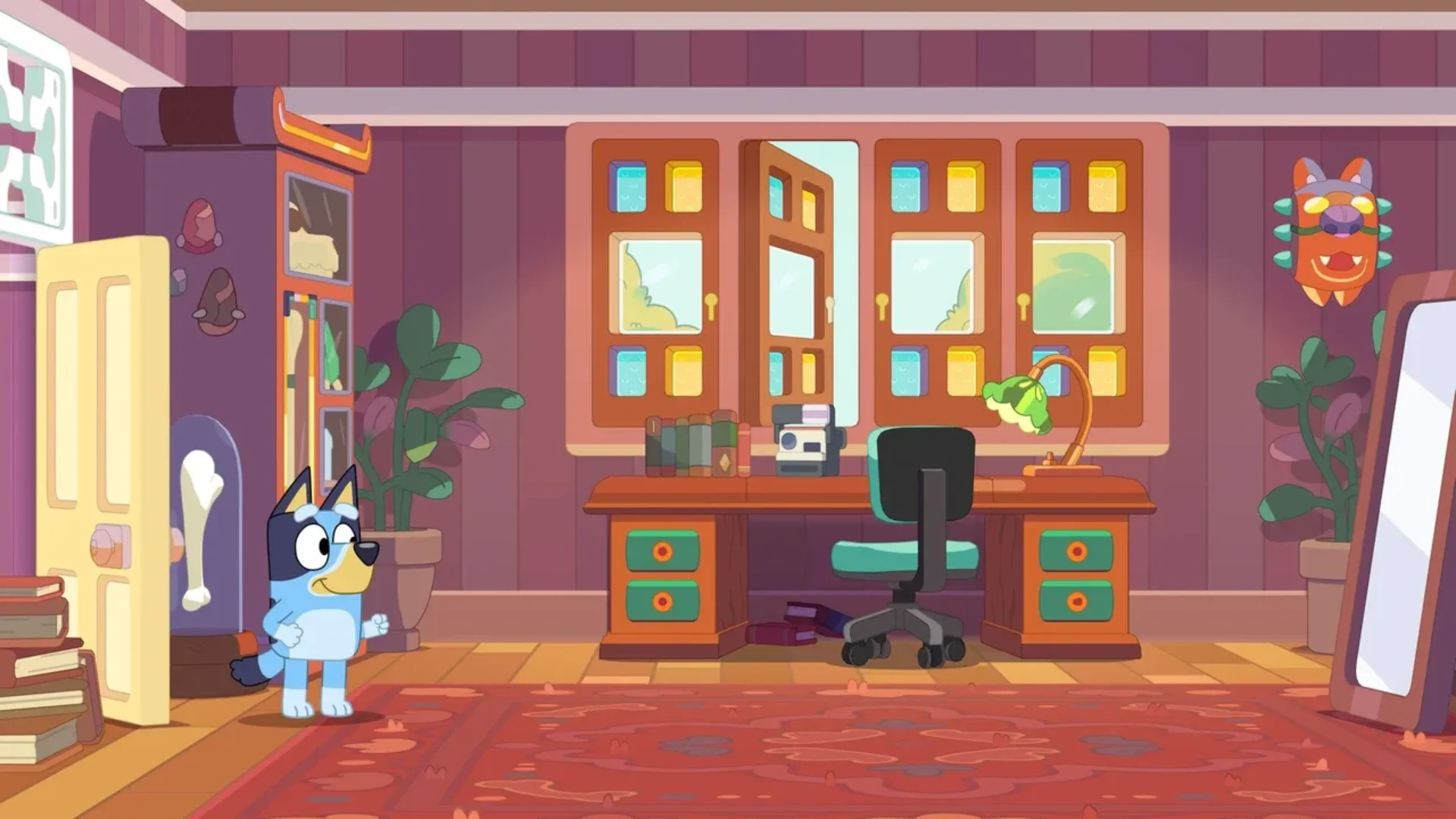 Bluey explores a colorful room with books, a desk and camera in Bluey's Happy Snaps