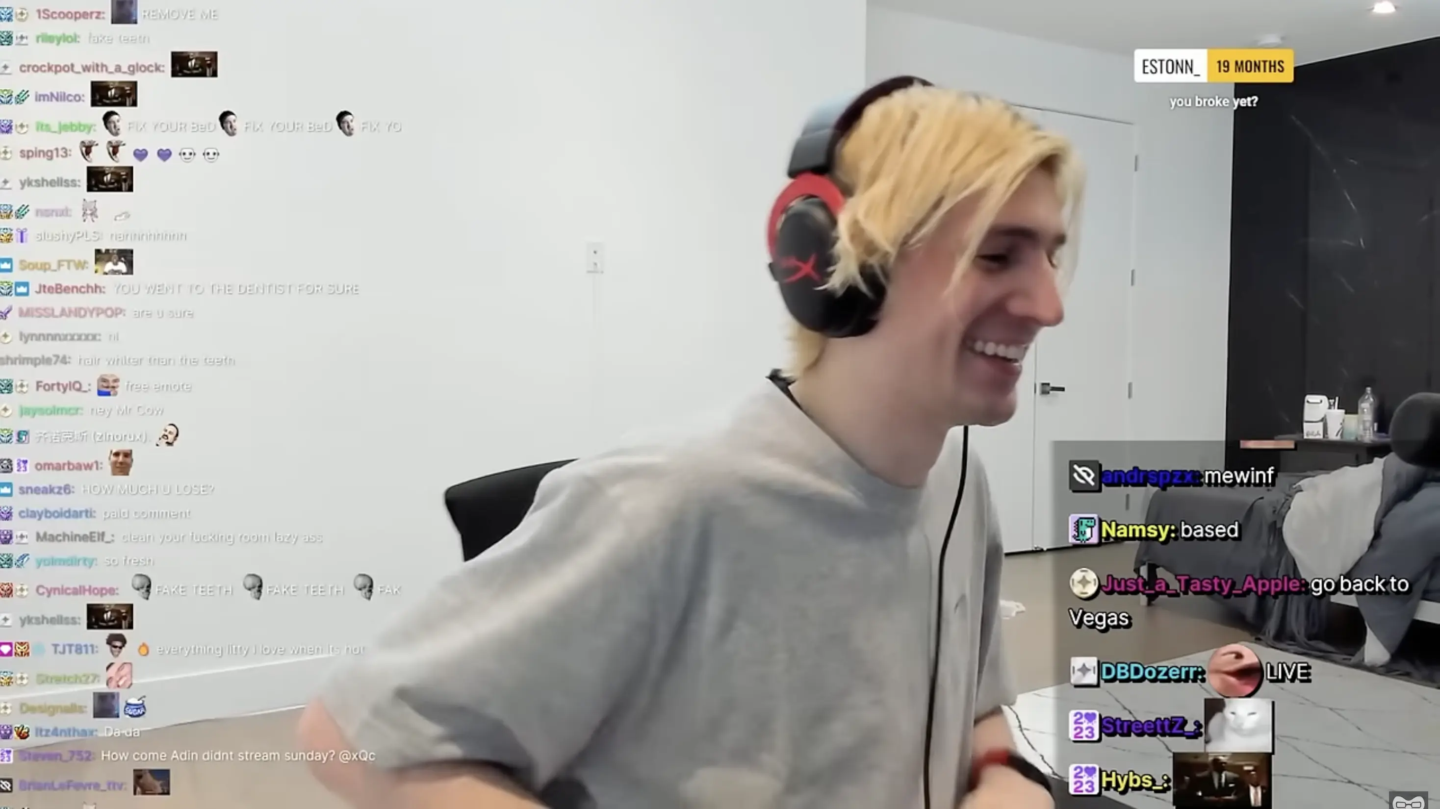 xQc smiling during a livestream while reading messages from his Twitch chat.